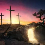 Tres cruces de madera en una colina bajo un cielo de atardecer vibrante y una tumba vacía que emite luz dorada.