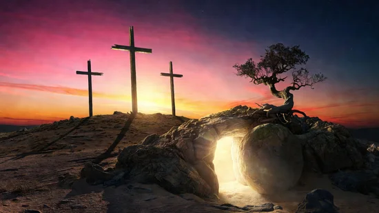 Tres cruces de madera en una colina bajo un cielo de atardecer vibrante y una tumba vacía que emite luz dorada.