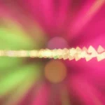 Fondo abstracto con ráfagas de luz magenta, verde neón y bokeh blanco en movimiento dinámico de larga exposición.