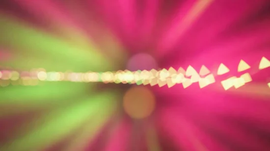 Fondo abstracto con ráfagas de luz magenta, verde neón y bokeh blanco en movimiento dinámico de larga exposición.