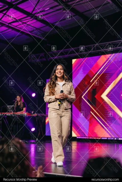 Mujer lider alabanza chaqueta denim beige microfono pantalla LED chevrones morado rosa teclado escenario luces culto contemporaneo vertical alegre