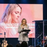 Mujer biblia abierta pantalla reuniao de mulheres portugues evento femenino ministerio mujeres iglesia vertical luminoso