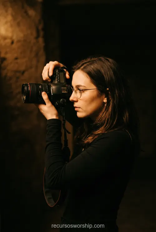 Mujer fotografa camara canon dslr lente profesional culto adoracion luces escenario produccion medios iglesia vertical oscuro