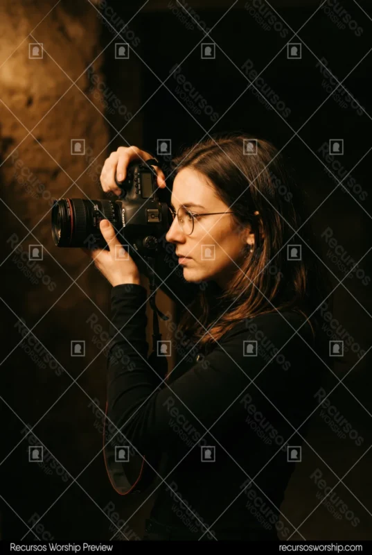 Mujer fotografa camara canon dslr lente profesional culto adoracion luces escenario produccion medios iglesia vertical oscuro