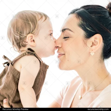 Bebe rubia vestido marrón dando beso nariz con nariz a madre morena cabello recogido ojos cerrados sonriendo fondo blanco luminoso vertical plano busto