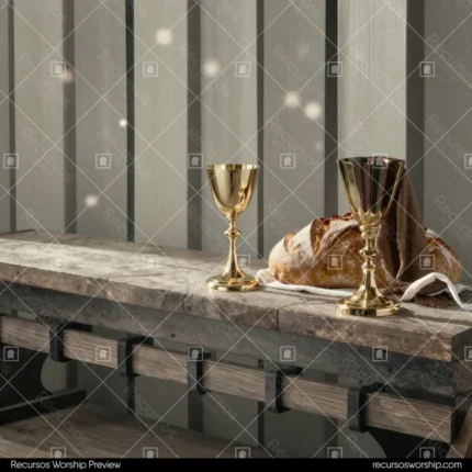 Copa dorada comunion jarra dorada mesa madera rustica oscura pan artesanal partido tela blanca cinta tablones grises cuadrado devocional solemne calido santa cena eucaristia