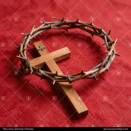 Cruz pequeña de madera clara en el centro de corona de espinas de ramas secas sobre tela roja carmín intensa ángulo elevado