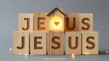 Primer plano bloques madera letras jesus dos filas fila inferior completa bloque central casita corazon luminoso naranja calido fondo gris neutro cuadrado creativo devocional