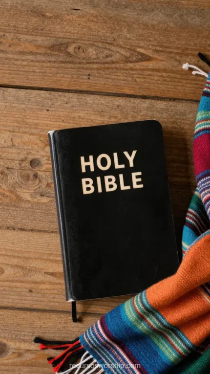 Holy Bible negra con letras doradas sobre madera oscura rústica junto a manta étnica rayada multicolor azul rojo naranja verde cenital
