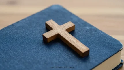 Primer plano horizontal de Biblia azul marino cerrada con cruz de madera natural inclinada sobre cubierta fondo madera bokeh cálido
