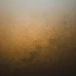Superficie metalica envejecida patina bronce dorado gris texturizado manchas irregulares oscuras vertical rugoso artesanal burnished laton premium textura diseno overlay editorial branding