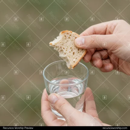Manos adultas sosteniendo pan artesanal partido vaso vidrio agua transparente fondo natural verde borroso plano picado intimo cuadrado minimalista comunion sencilla natural santa cena