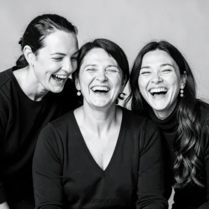 Retrato blanco negro madre madura centro dos hijas adultas lados riendo carcajadas expresividad ropa negra fondo gris estudio horizontal plano busto alegre