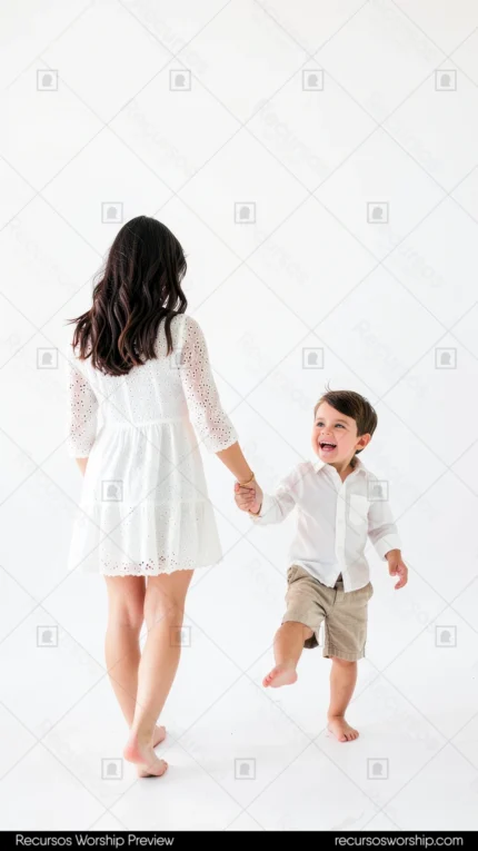 Madre morena cabello largo vestido blanco hijo pequeño descalzo camisa beige tomados mano estudio blanco puro niño girando risa espontanea juego vertical plano general