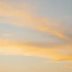 Cielo atardecer nubes cirro-estratus iluminadas naranja dorado suave fondo celeste azul palido fotografia real vertical majestuosa contemplativa natural creacion gloria dios