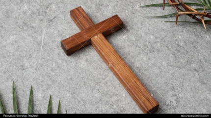 Cruz madera rustica grande horizontal superficie piedra gris rama palma verde izquierda corona espinas beige derecha cenital horizontal simbolos pasion semana santa liturgico rustico
