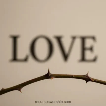Primer plano de rama delgada con espinas desenfocada con la palabra LOVE en tipografia serif grande al fondo beige crema cuadrado poético conceptual